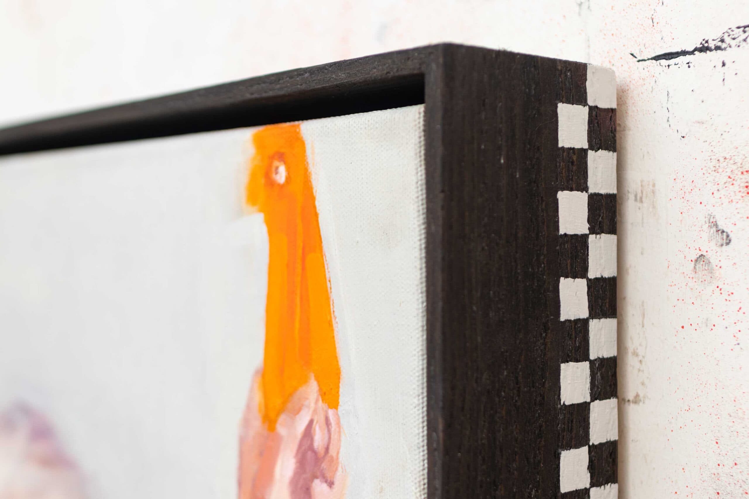 Handmade floater frame in matte black with a natural rough wooden surface and subtle checkerboard ribbon